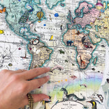 Hand pointing at a world map with illustrations on a colorful background