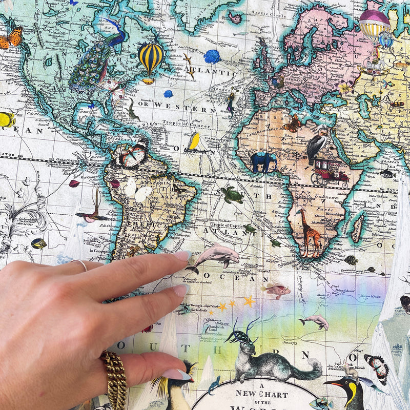 Hand pointing at a world map with illustrations on a colorful background